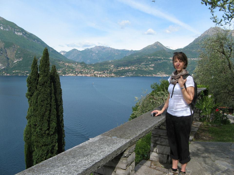 Canadian watercolour artist Brigitte Klassen standing by Lake Como in Italy with mountains and blue water in the background