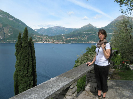 Canadian watercolour artist Brigitte Klassen standing by Lake Como in Italy with mountains and blue water in the background