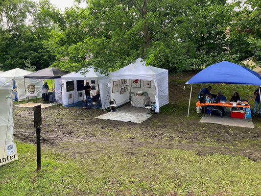 Canadian watercolour artist Brigitte Klassen's white tent booth displaying framed paintings at Art in the Park outdoor art festival in Ottawa